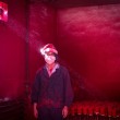 Wei (19) works in a factory in Yiwu, eastern China, coating polystyrene snowflakes with red powder. He wears a Christmas hat to protect his hair, and goes through at least six face masks a day. (Ronghui Chen, Contemporary Issues, 2nd prize singles)